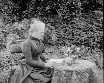 Mother reading at table in garden Original caption: Mother reading at table in garden