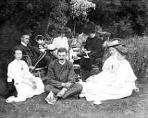 Ladies and gents having tea on lawn Original caption: Ladies and gents having tea on lawn