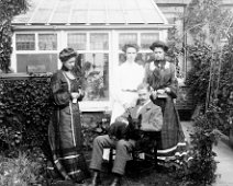 3 girls , gent and a dog in a garden Original caption: 3 girls , gent and a dog in a garden