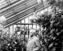 Mr. Kennedy in green house without hat Original caption: Mr. Kennedy in green house without hat