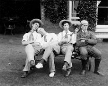 Gilbert + 3 others on bench with tennis raquets outside the drawing room window, Sedgeford Hall Original caption: Gilbert + 3 others on bench with tennis raquets