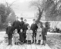 Miss. B. with 9 children in snow Sedgeford Hall Original caption: Miss. B. with 10 children in snow
