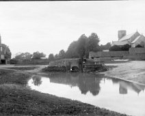 Village bridge scene with Sedgeford church West Hall Farm, bridge, pond, barns and Sedgeford church beyond Original caption: Village bridge scene