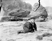 Splat Cove Original caption: Boy in sailor suit on beach