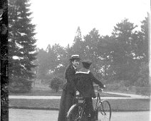 Girl with boy in sailor suit on bicycle Original caption: Girl with boy in sailor suit on bicycle